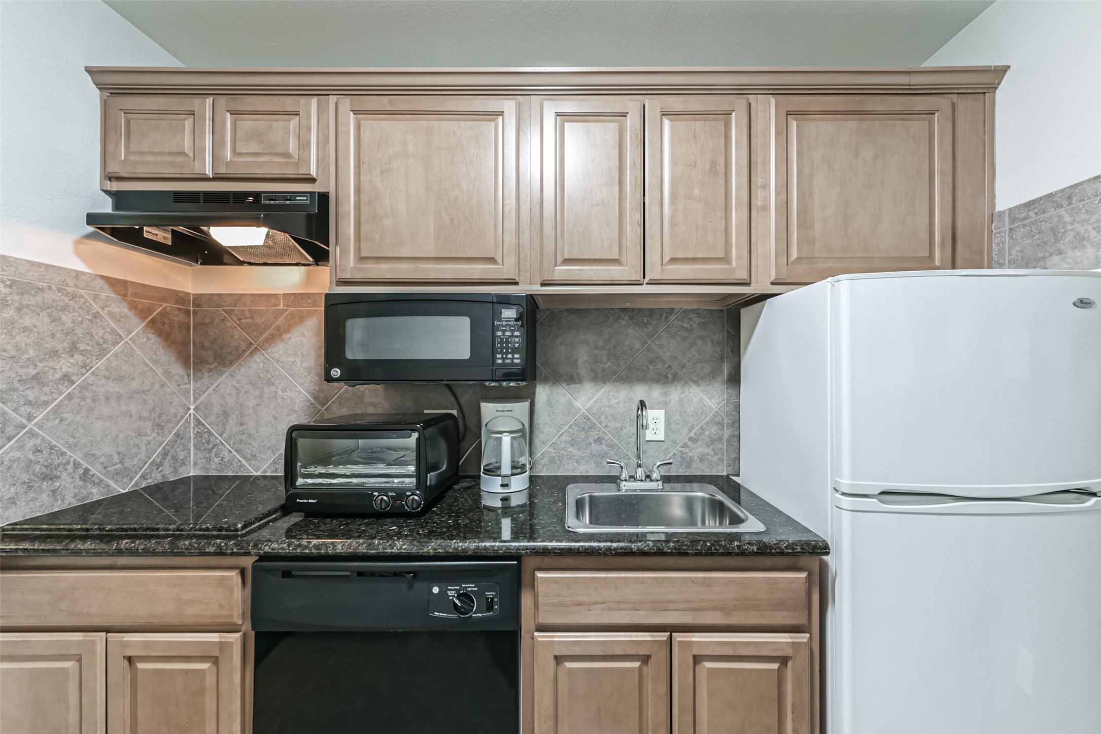 1025 Swanson Street, Unit 311 Houston, TX 77030 - Photo 12 of 26 a kitchen with granite countertop white cabinets and stainless steel appliances