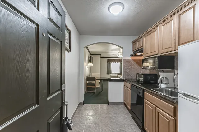 a kitchen with stainless steel appliances granite countertop a stove a sink and a refrigerator