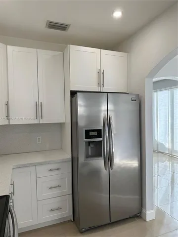 a metallic refrigerator freezer sitting in a kitchen