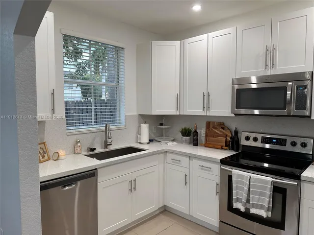 a kitchen with stainless steel appliances granite countertop a sink a stove a microwave and cabinets