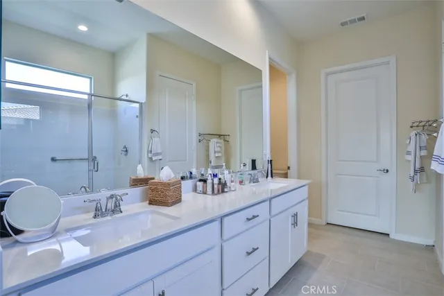 a en suite bathroom with double vanity and a bathtub