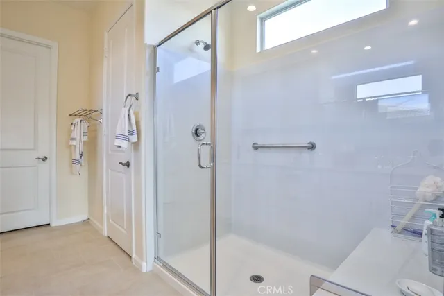 a bedroom with a bed a dresser and next to a window