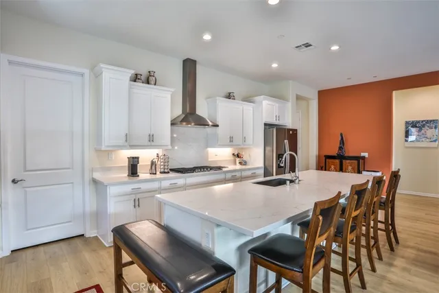 a kitchen with a dining table chairs and wooden floor