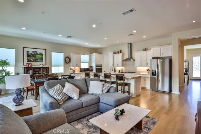 a living room with furniture kitchen view and a refrigerator