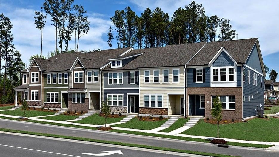 a view of a white house with large windows and a table and chairs