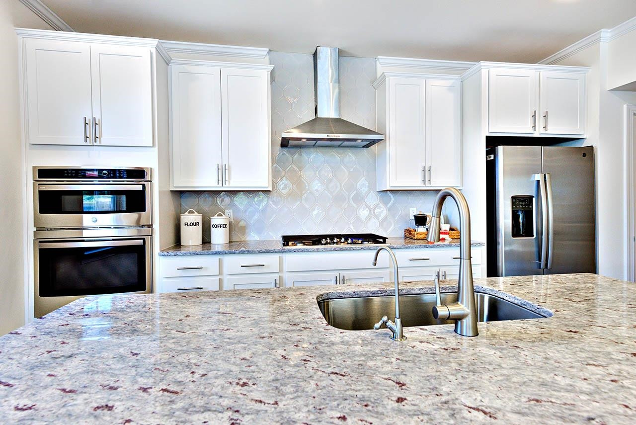 1714 Wimberly Road Apex, NC 27523 - Photo 13 of 45 a kitchen with stainless steel appliances kitchen island granite countertop a stove a sink and a refrigerator