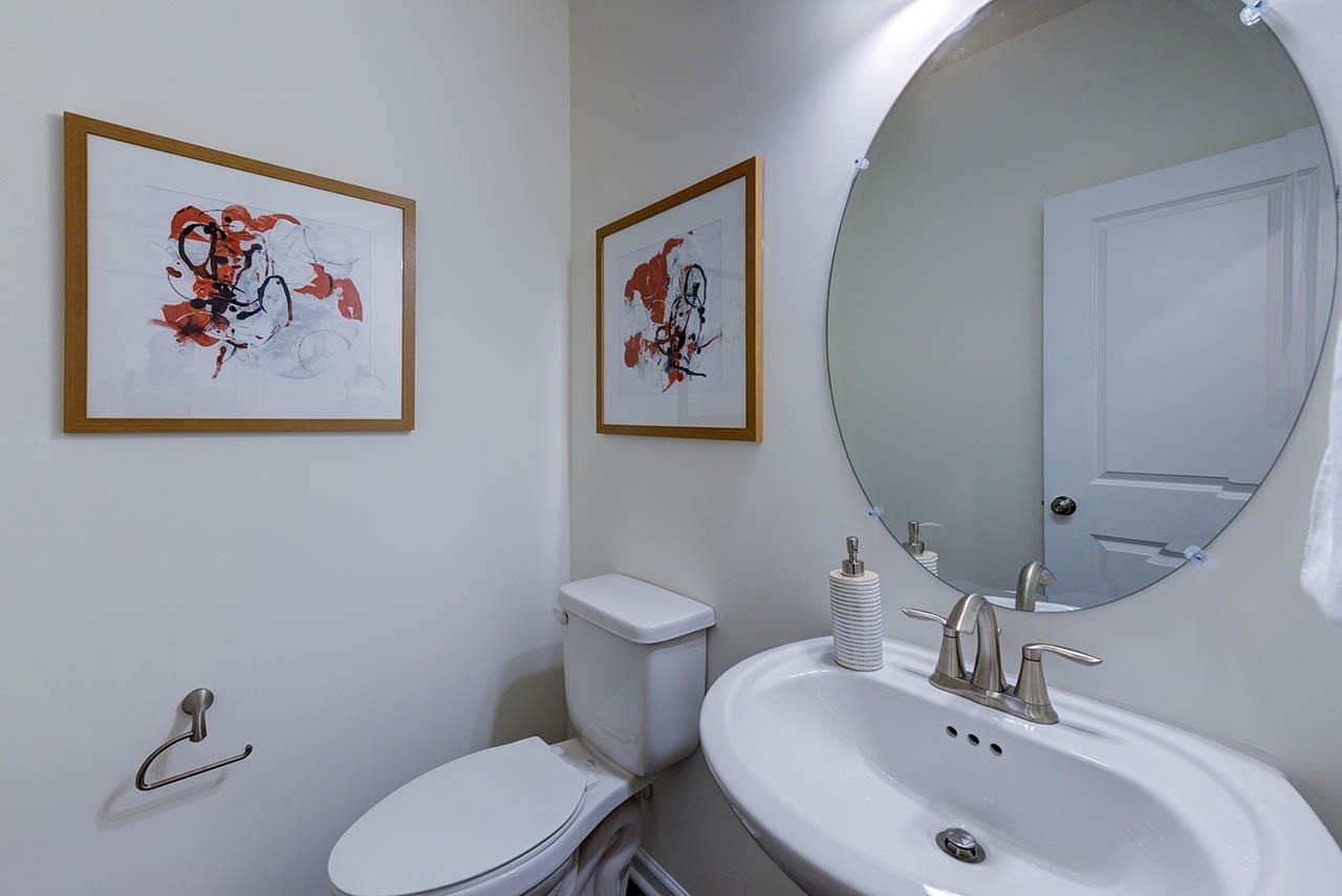 1714 Wimberly Road Apex, NC 27523 - Photo 19 of 45 a bathroom with a toilet a sink and mirror