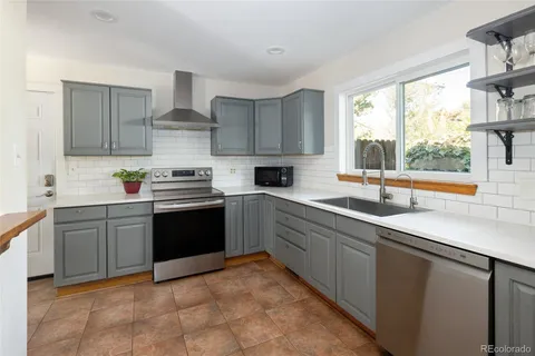 a kitchen with a sink window and cabinets