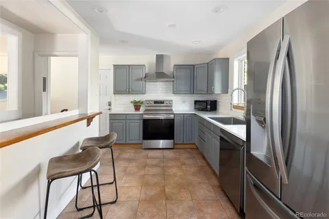 a large kitchen with stainless steel appliances lots of white cabinets