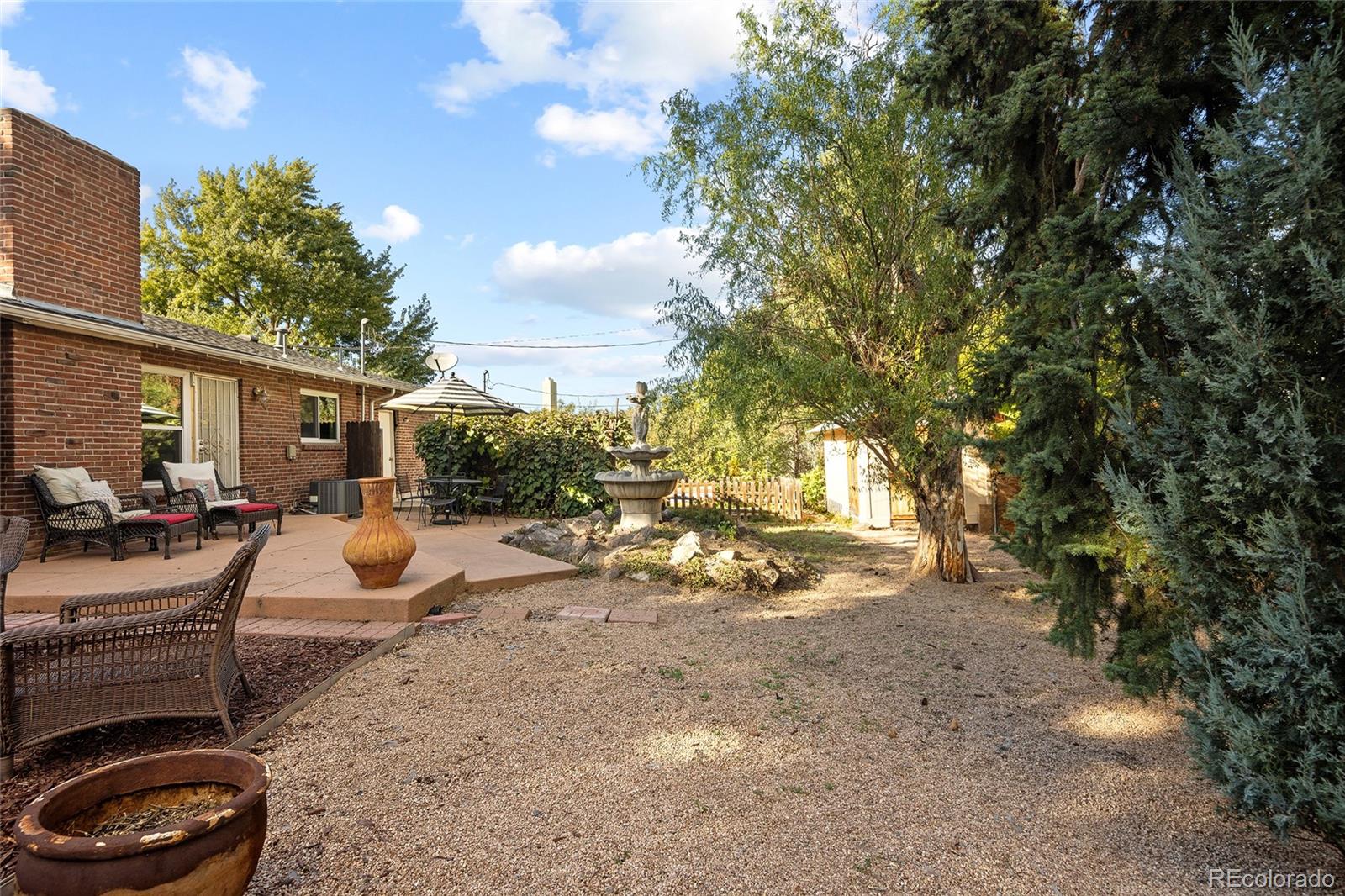 1550 South Forest Street Denver, CO 80222 - Photo 27 of 38 a view of a backyard with table and chairs and a large tree