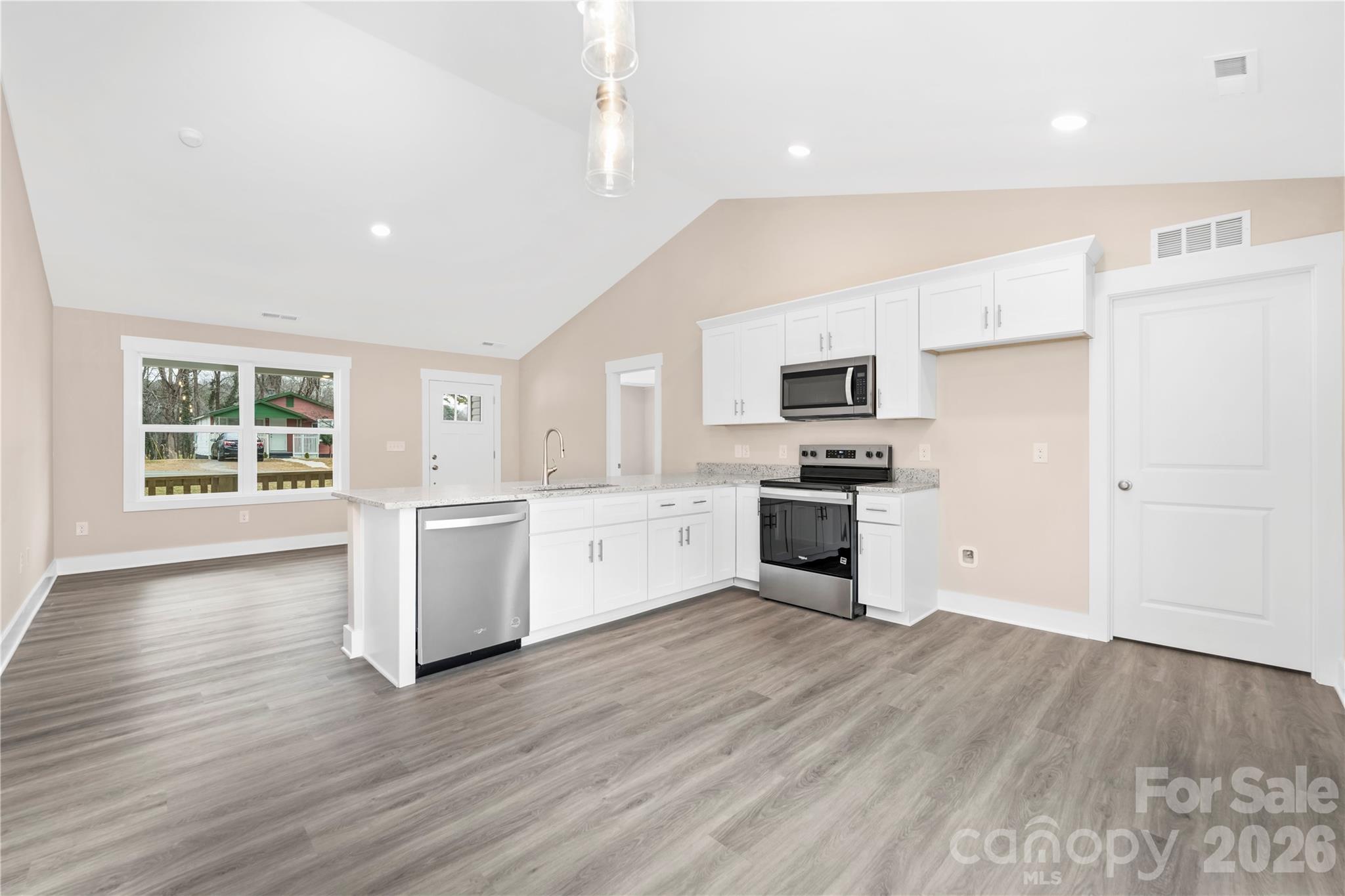 407 Queens Road Gastonia, NC 28052 - Photo 11 of 34 a kitchen with granite countertop a refrigerator oven a sink dishwasher and white cabinets with wooden floor