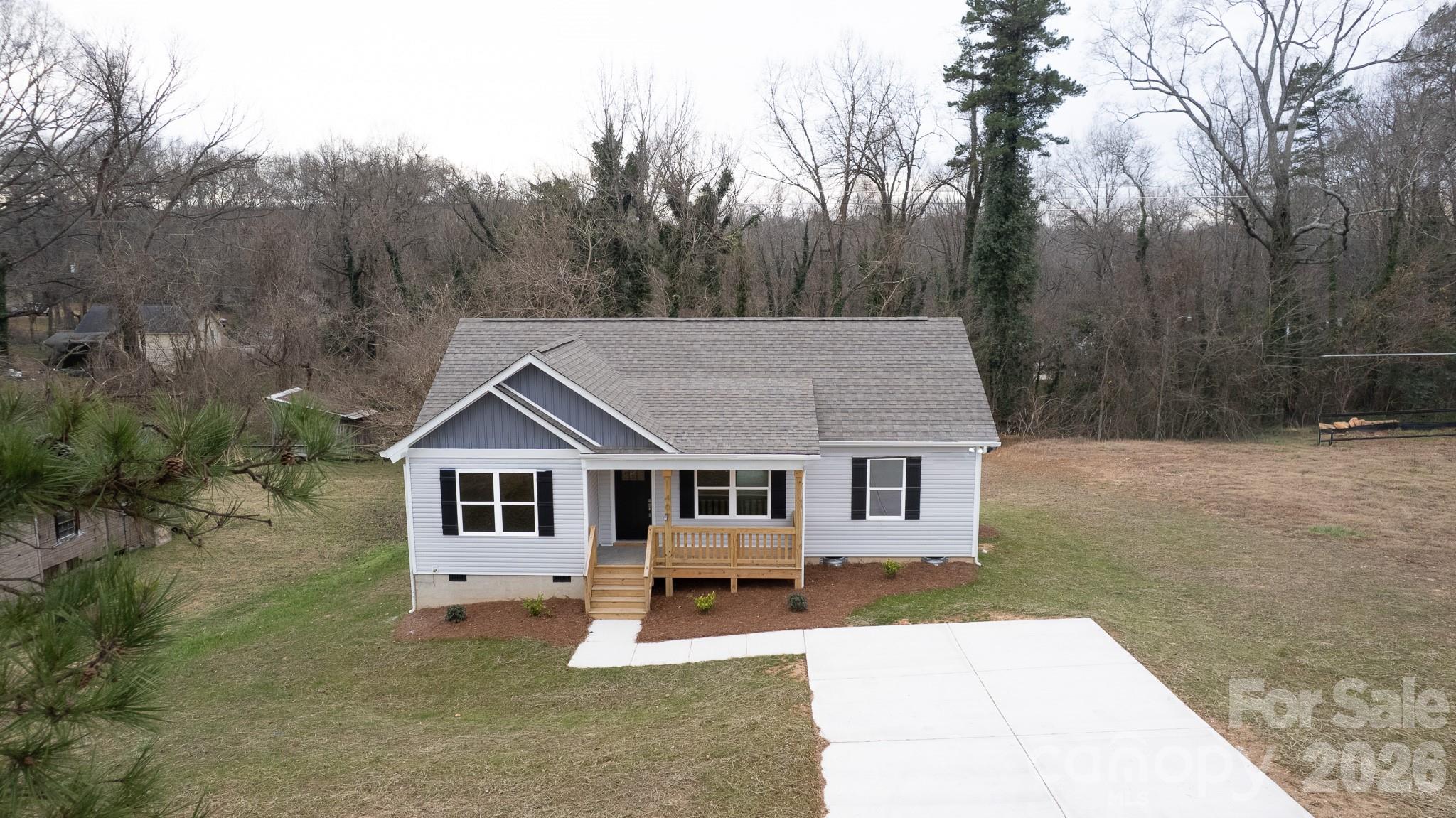 407 Queens Road Gastonia, NC 28052 - Photo 31 of 34 a front view of a house with a yard tree and wooden fence