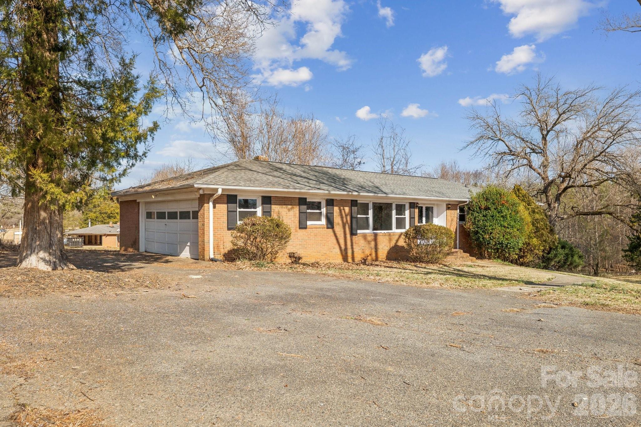 9525 Brief Road Charlotte, NC 28227 - Photo 38 of 46 a front view of a house with a garden and trees