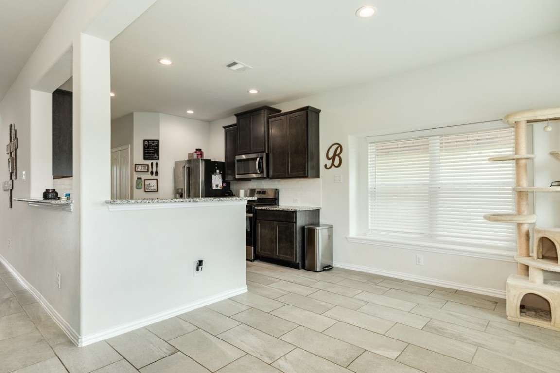 177 Bayou Bend Boulevard Angleton, TX 77515 - Photo 15 of 33 a kitchen with stainless steel appliances kitchen island granite countertop a refrigerator and a sink