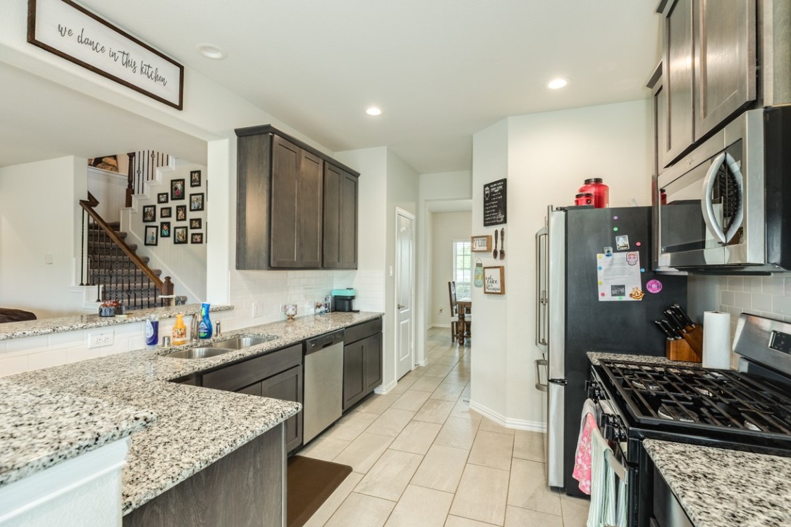177 Bayou Bend Boulevard Angleton, TX 77515 - Photo 16 of 33 a kitchen with stainless steel appliances granite countertop a sink stove and refrigerator