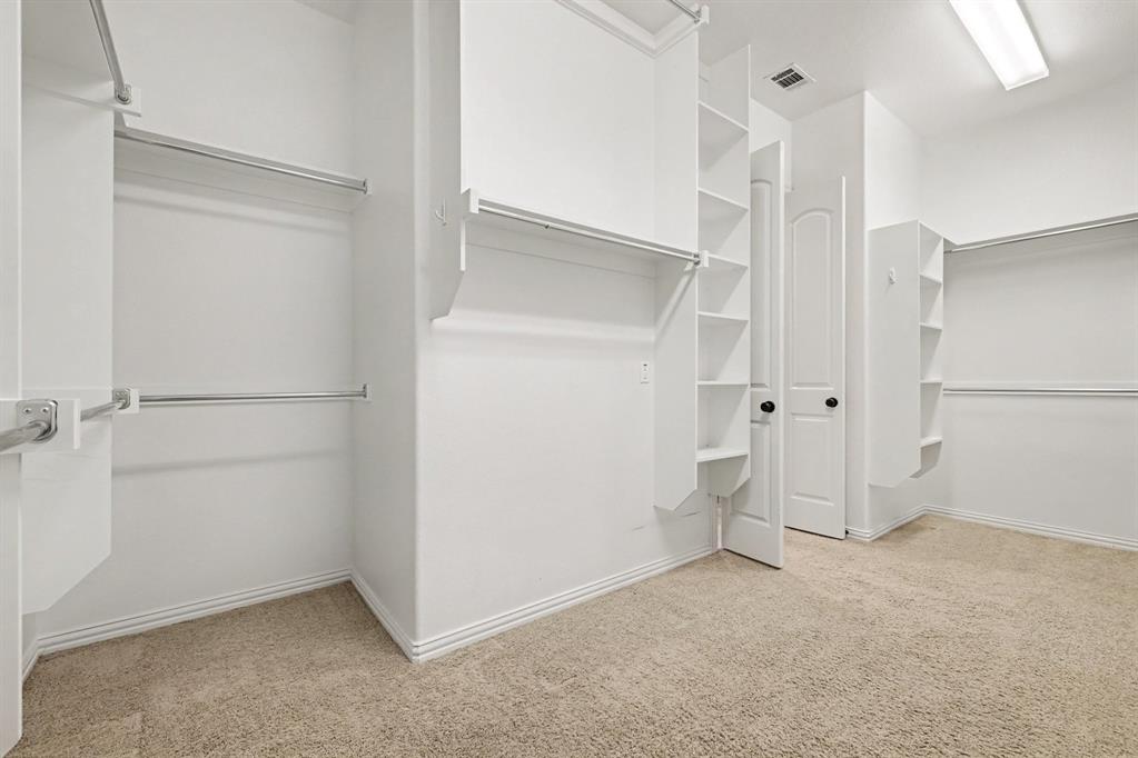 408 Blue Ridge Court Allen, TX 75013 - Photo 22 of 31 Walk-in closet featuring carpet flooring, built-in shelving, chrome hanging rods, and a flush-mount ceiling light