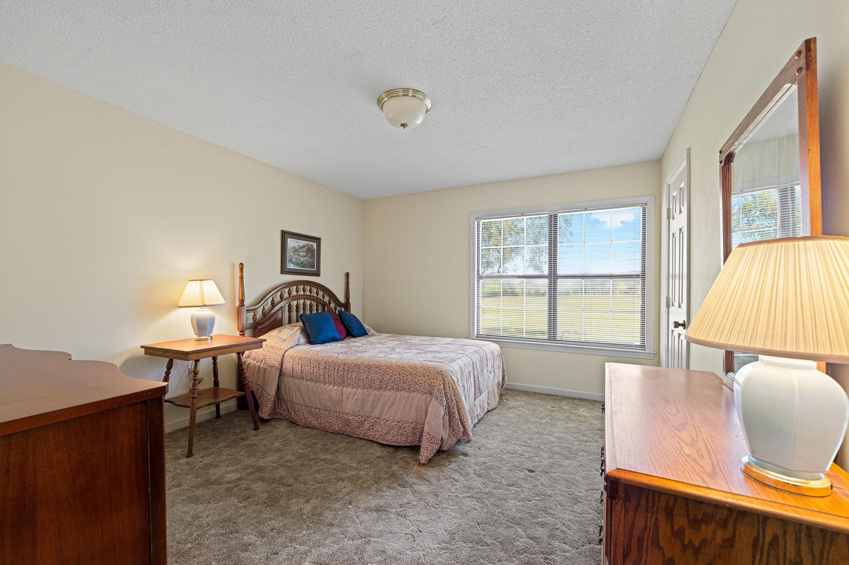 650 Blain Road Rossville, TN 38066 - Photo 18 of 26 With abundant natural light from the large window and soft carpet underfoot, this bedroom offers a cozy, inviting environment. The room's airy feel makes it perfect for rest, reading, or quiet reflection.