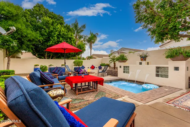 a view of a patio with a table and chairs under an umbrella