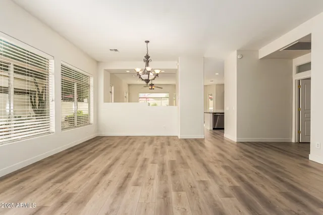 a view of a livingroom with wooden floor and kitchen space