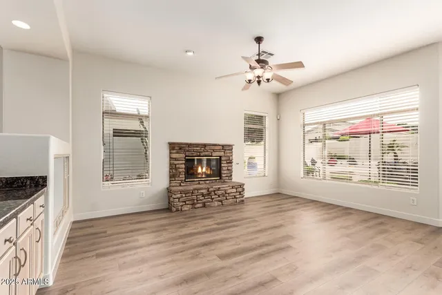 a view of an empty room with a window and a kitchen