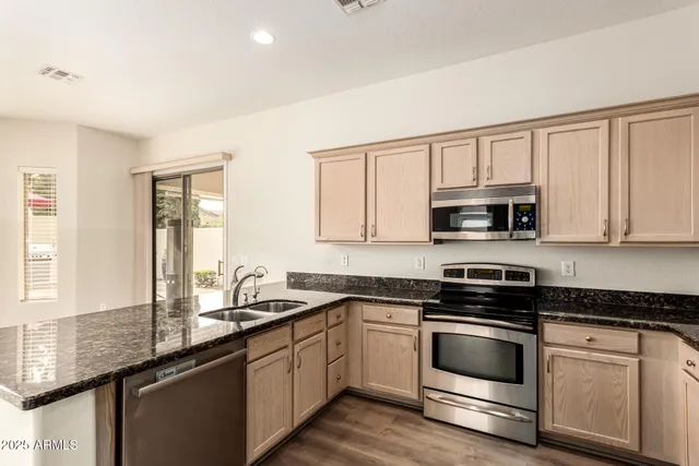 a kitchen with stainless steel appliances granite countertop white cabinets granite counter tops and a window