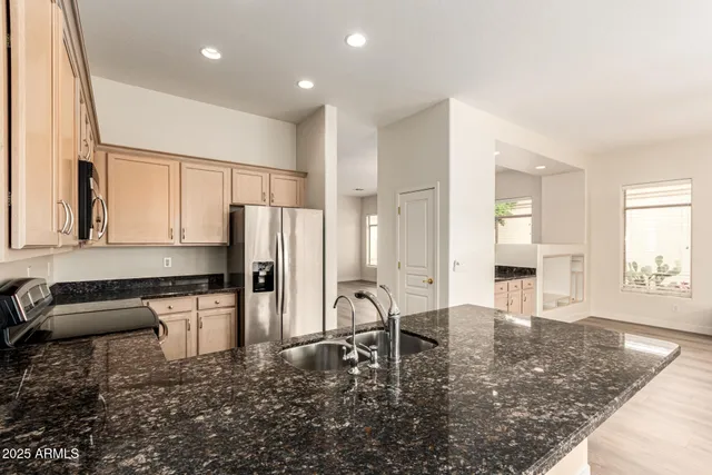 a kitchen with granite countertop sink cabinets and stainless steel appliances