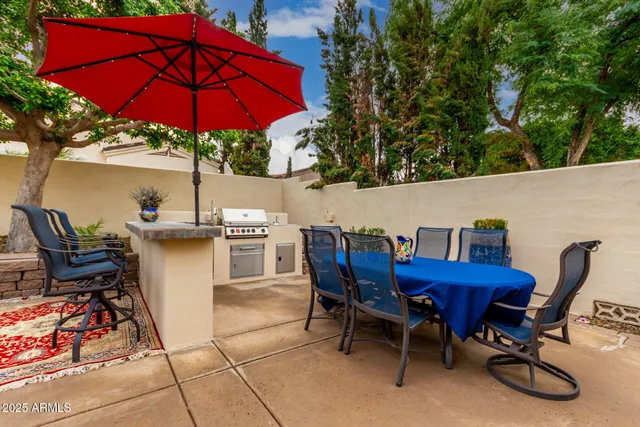 a view of a patio with a table and chairs under an umbrella