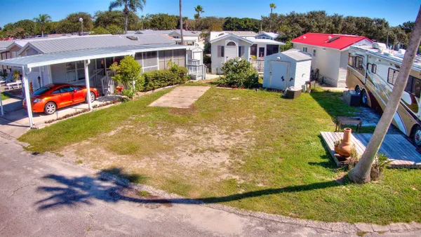 a view of a house with a yard and potted plants