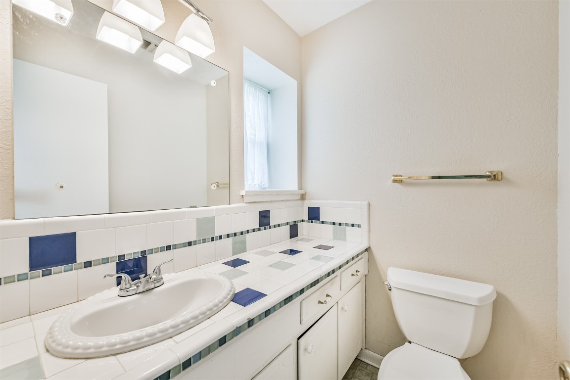 823 Townley Street Channelview, TX 77530 - Photo 16 of 29 a bathroom with a sink a toilet a mirror and shower curtain