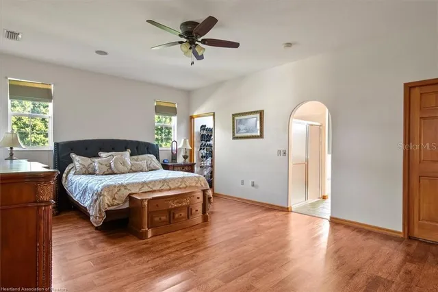a spacious bedroom with a bed and a chandelier