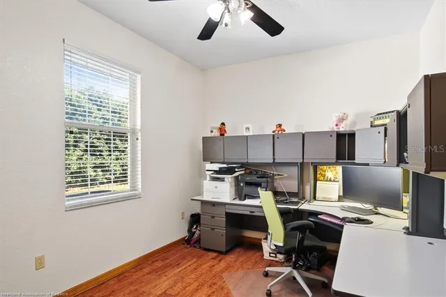 a view of a workspace with furniture and a window