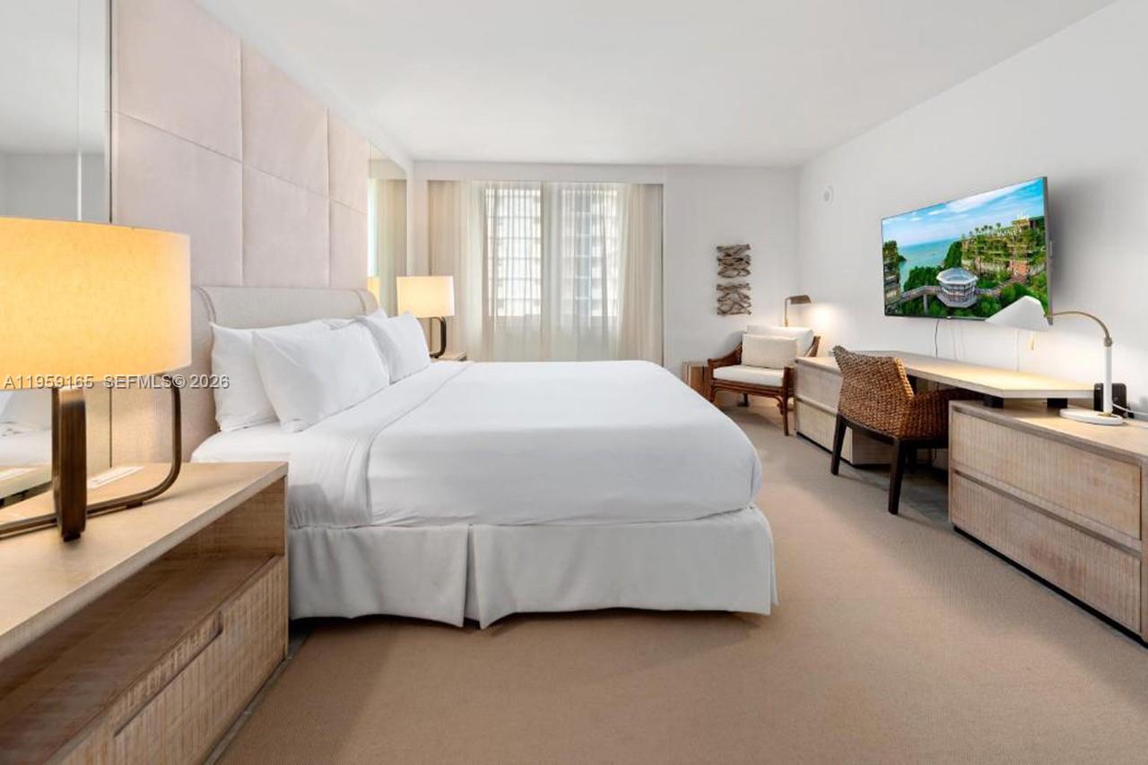 102 24th Street, Unit 1007 Miami Beach, FL 33139 - Photo 3 of 23 a spacious bedroom with a bed a couch and large window