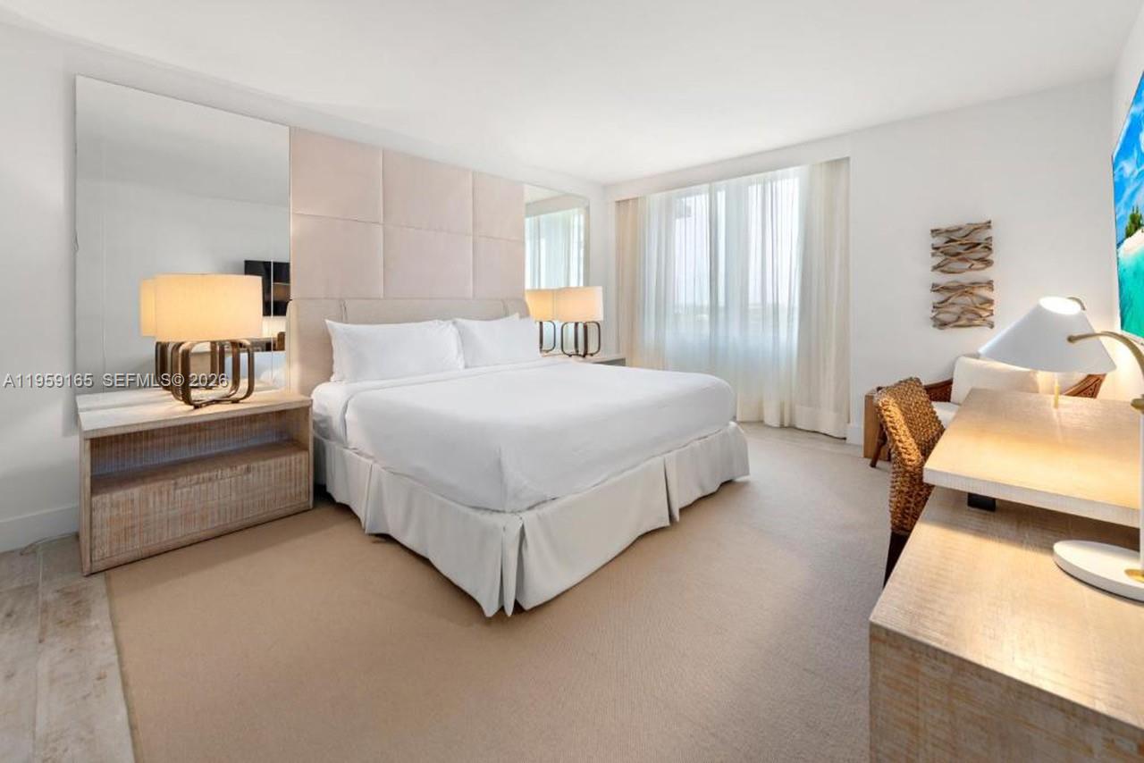 102 24th Street, Unit 1007 Miami Beach, FL 33139 - Photo 4 of 23 a bedroom with a bed and lamp