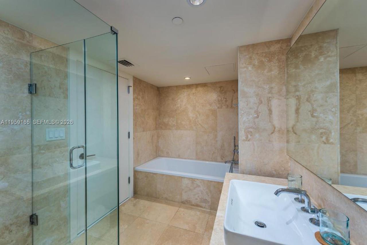 102 24th Street, Unit 1007 Miami Beach, FL 33139 - Photo 7 of 23 a bathroom with a shower and a sink