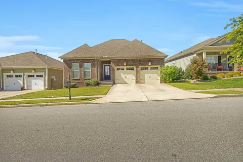 a front view of a house with a yard and potted plants