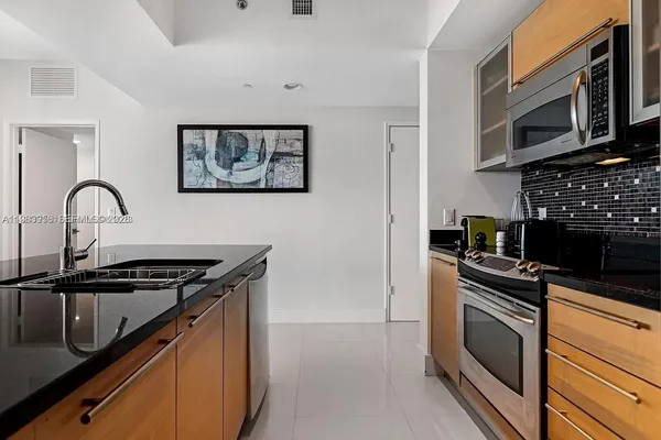 a kitchen with granite countertop a stove and a microwave