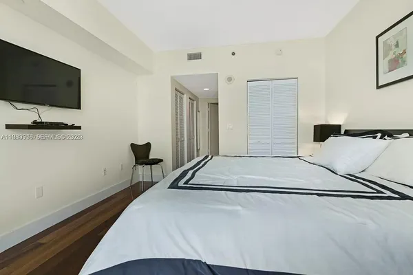 a bedroom with a bed and a flat screen tv