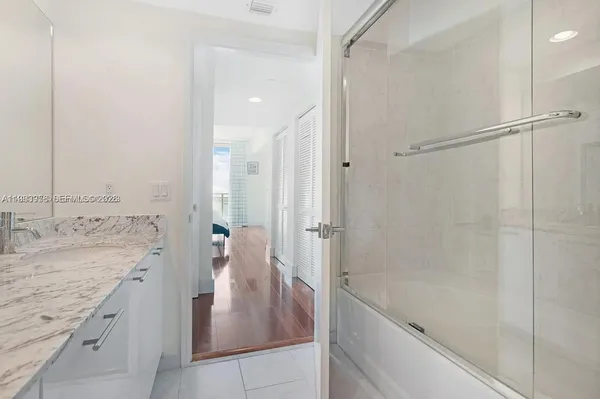 a bathroom with a granite countertop sink a shower and mirror