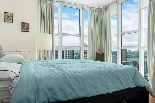 a bedroom with a bed and a large window