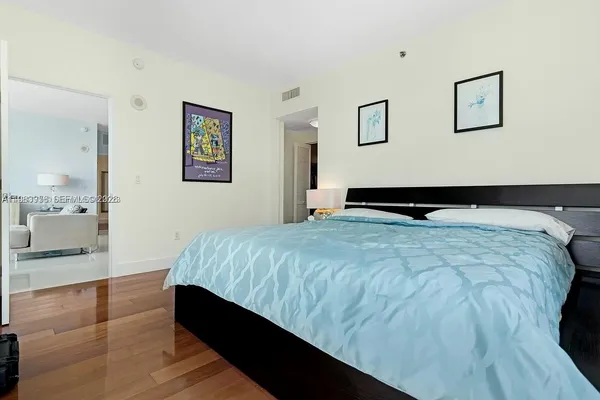 a bedroom with a bed and painting on the wall