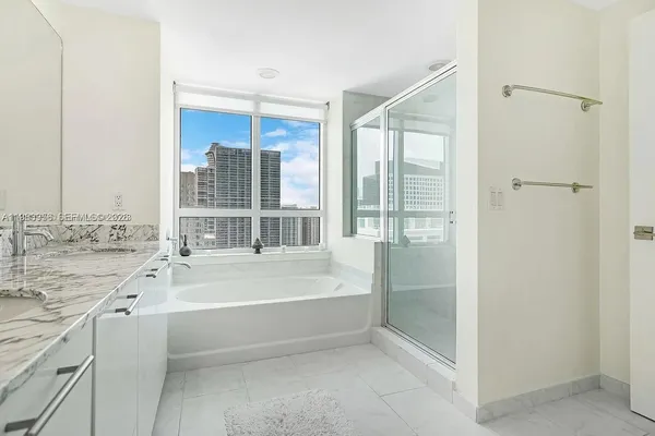 a bathroom with a tub sink and mirror