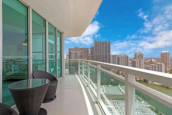 a view of a balcony with two chairs and a potted plant