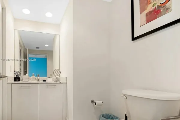a bathroom with a toilet sink and mirror