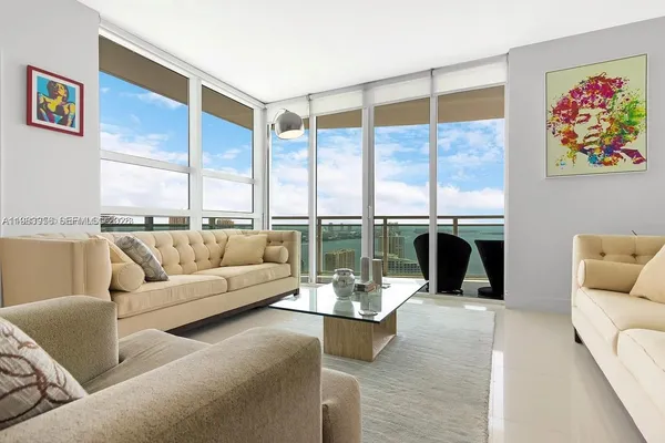 a living room with furniture a fireplace and floor to ceiling window