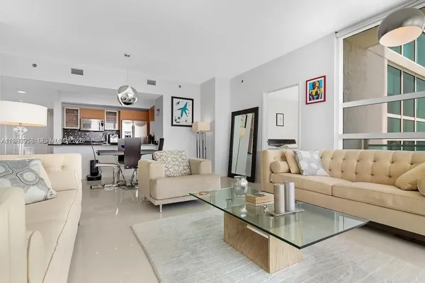 a living room with furniture and a view of kitchen