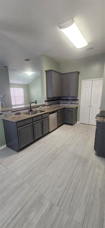 3709 Northpointe Drive Denton, TX 76207 - Photo 10 of 29 a large kitchen with kitchen island granite countertop wooden cabinets and stainless steel appliances