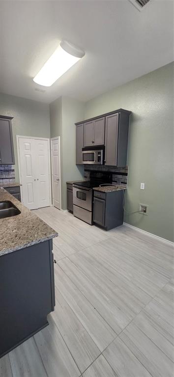3709 Northpointe Drive Denton, TX 76207 - Photo 9 of 29 a kitchen with stainless steel appliances wooden cabinets and granite counter tops