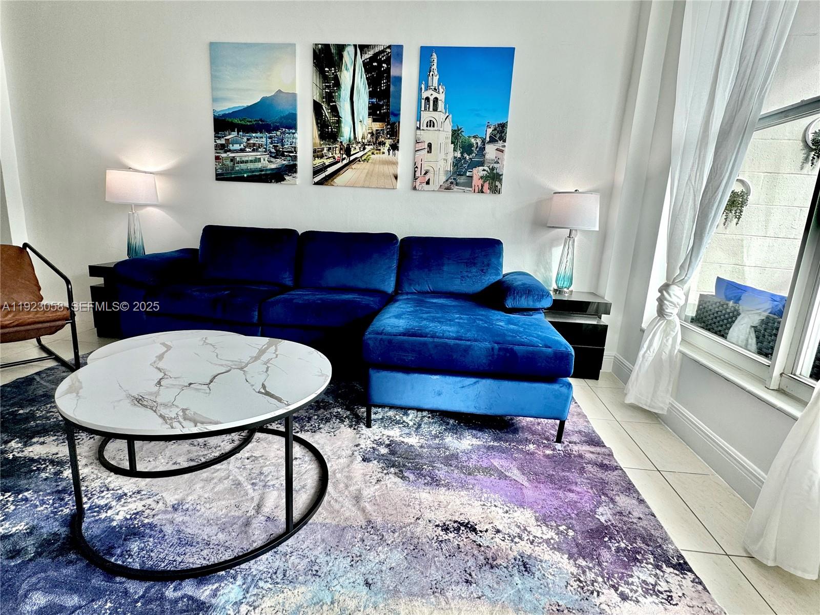 1300 Lincoln Road, Unit C903 Miami Beach, FL 33139 - Photo 3 of 13 a living room with furniture a rug and white walls