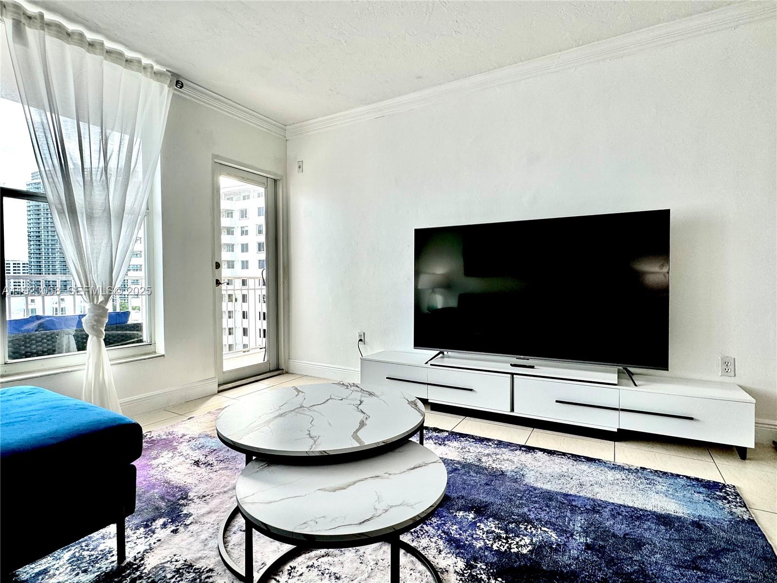 1300 Lincoln Road, Unit C903 Miami Beach, FL 33139 - Photo 5 of 13 a living room with furniture and a flat screen tv