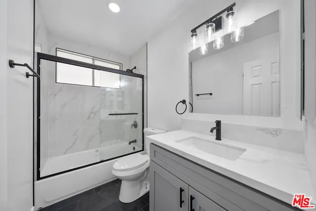 an empty room with wooden floor and a ceiling fan